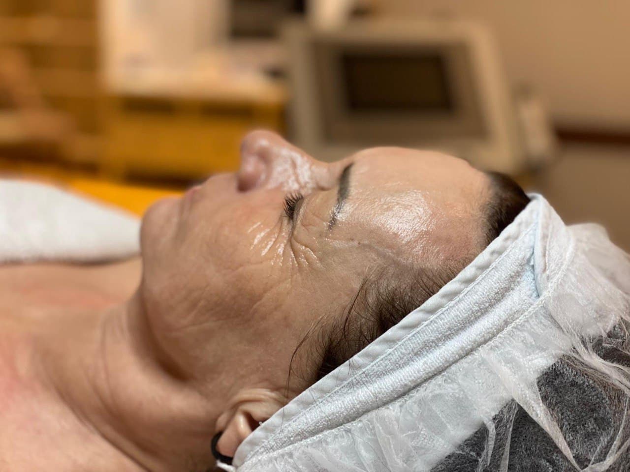 Gesichtsaufnahme mit geschlossenen Augen und Behandlungshaube